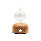 essential oil nebulizing diffuser made with glass bulb and wooden base. sleek, elegant design. nebulizer.